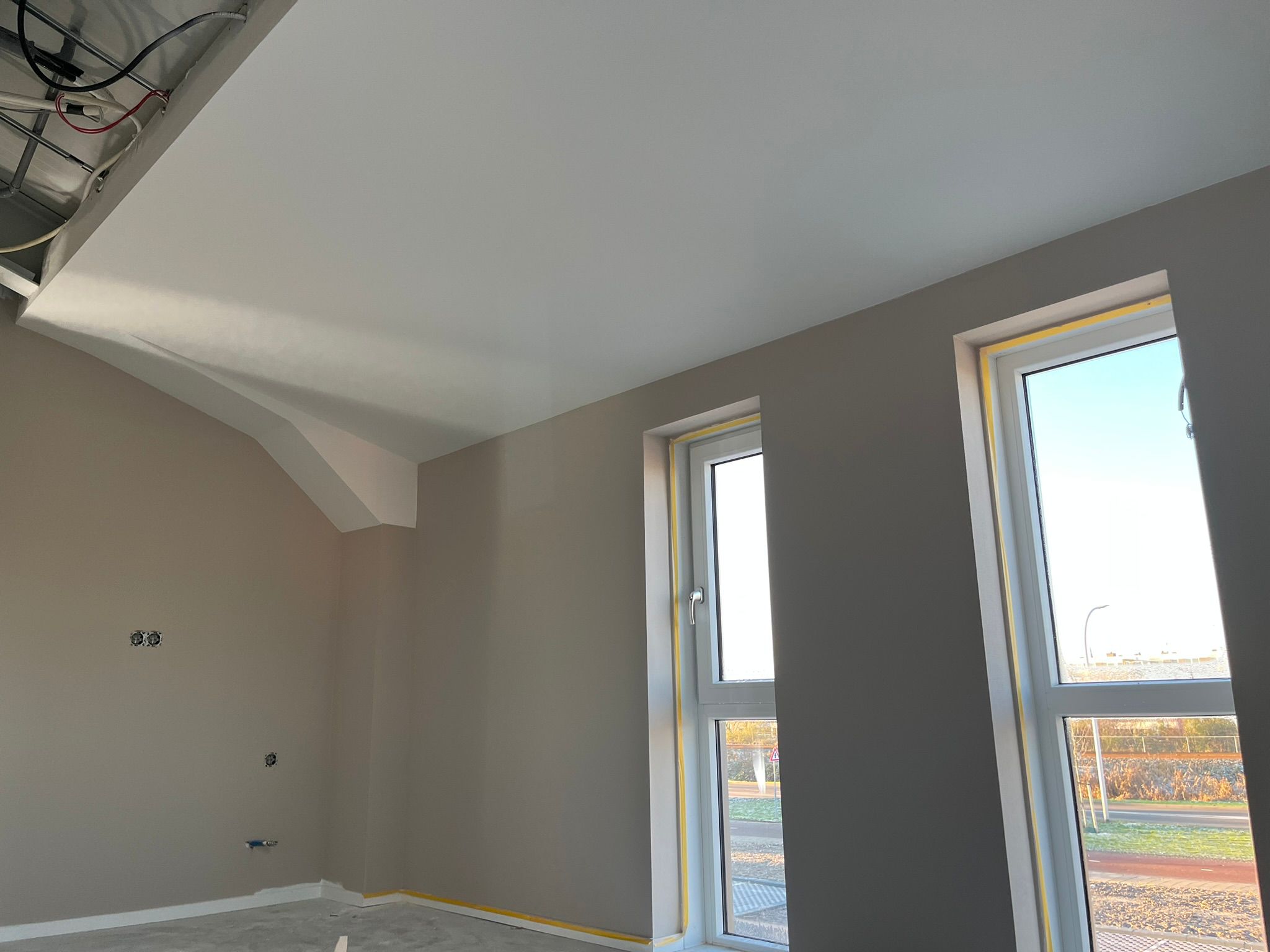 Strak afgewerkte kamer met hoge ramen