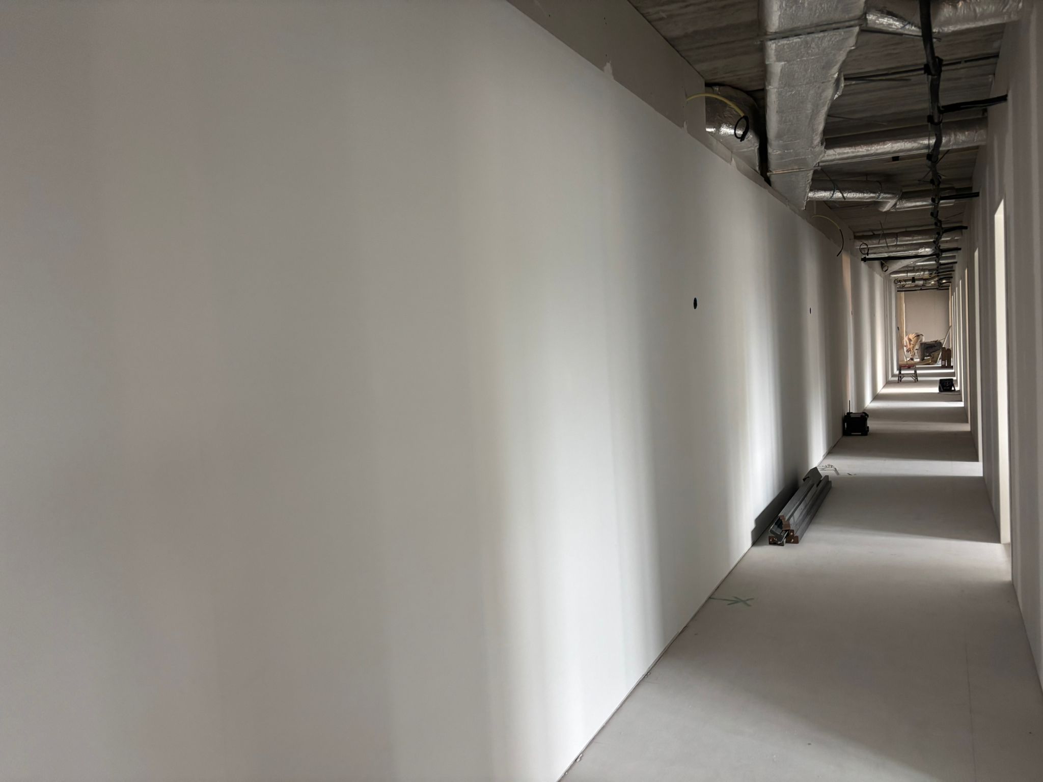 Lange gang met strak afgewerkte witte wanden