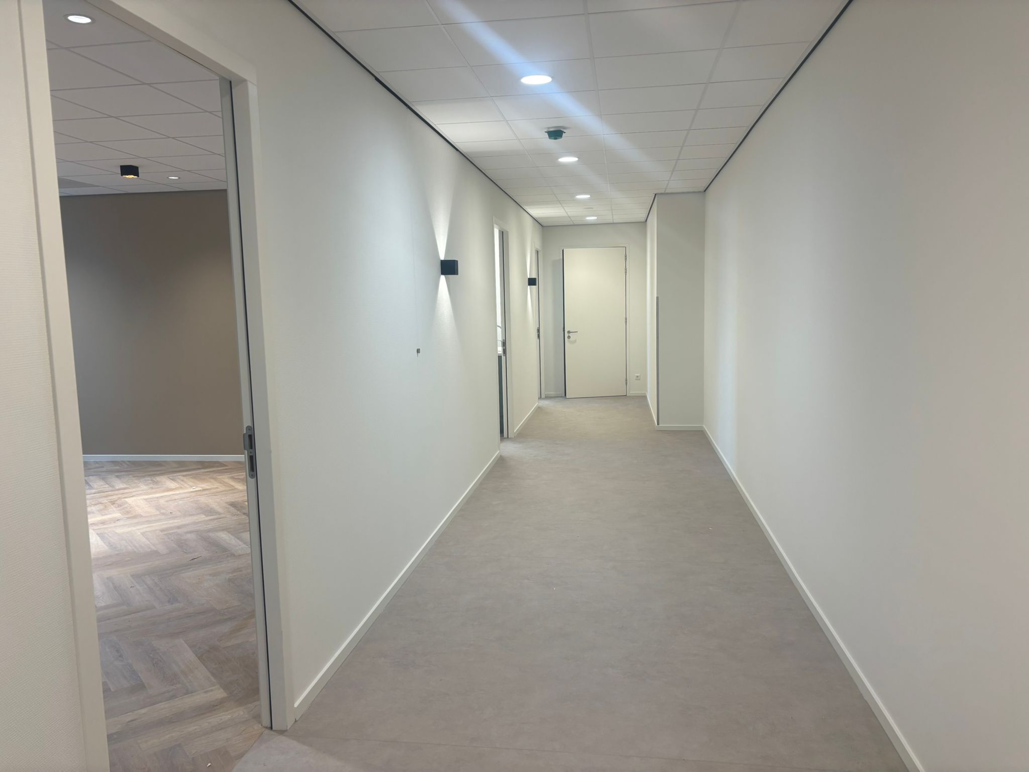 Afgewerkte gang met strakke lichte wanden