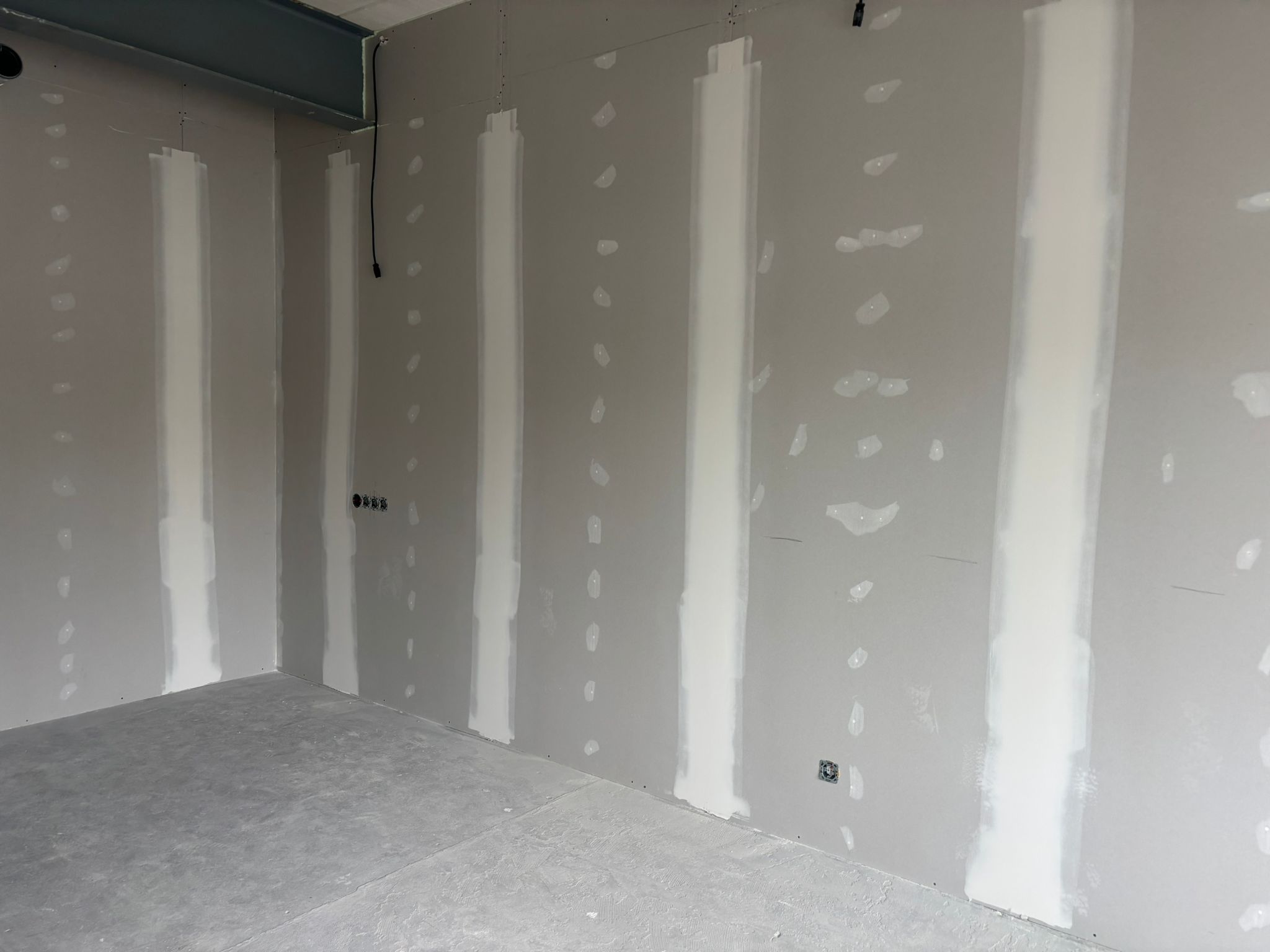 Strak afgewerkte witte wand in lichte ruimte